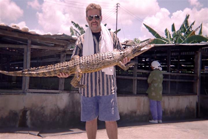 Picture image of Mark Erney holding crocodile at croc farm in Malaysia 1992